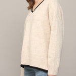 Oatmeal V-neck sweater side view showing high-low hem