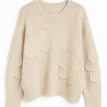Beige sweater with floral patterns on a white background