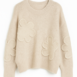 Beige sweater with floral patterns on a white background
