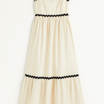 Beige dress with black trim on a white background