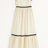 Beige dress with black trim on a white background