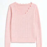 Pink cable knit sweater on a white background