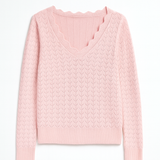 Pink cable knit sweater on a white background