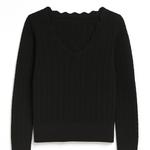 Black sweater with scalloped neckline on a white background