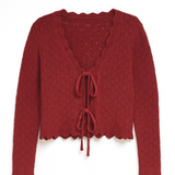 Red knitted cardigan with lace-up front on a white background