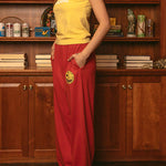 Woman wearing yellow Duvin In Training baby tee with red pants in styled interior setting
