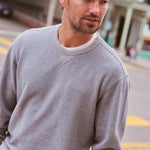 Marine Layer Cloud 9 Terry Relaxed Crewneck in Heather Grey Stripe layered under a bomber jacket
