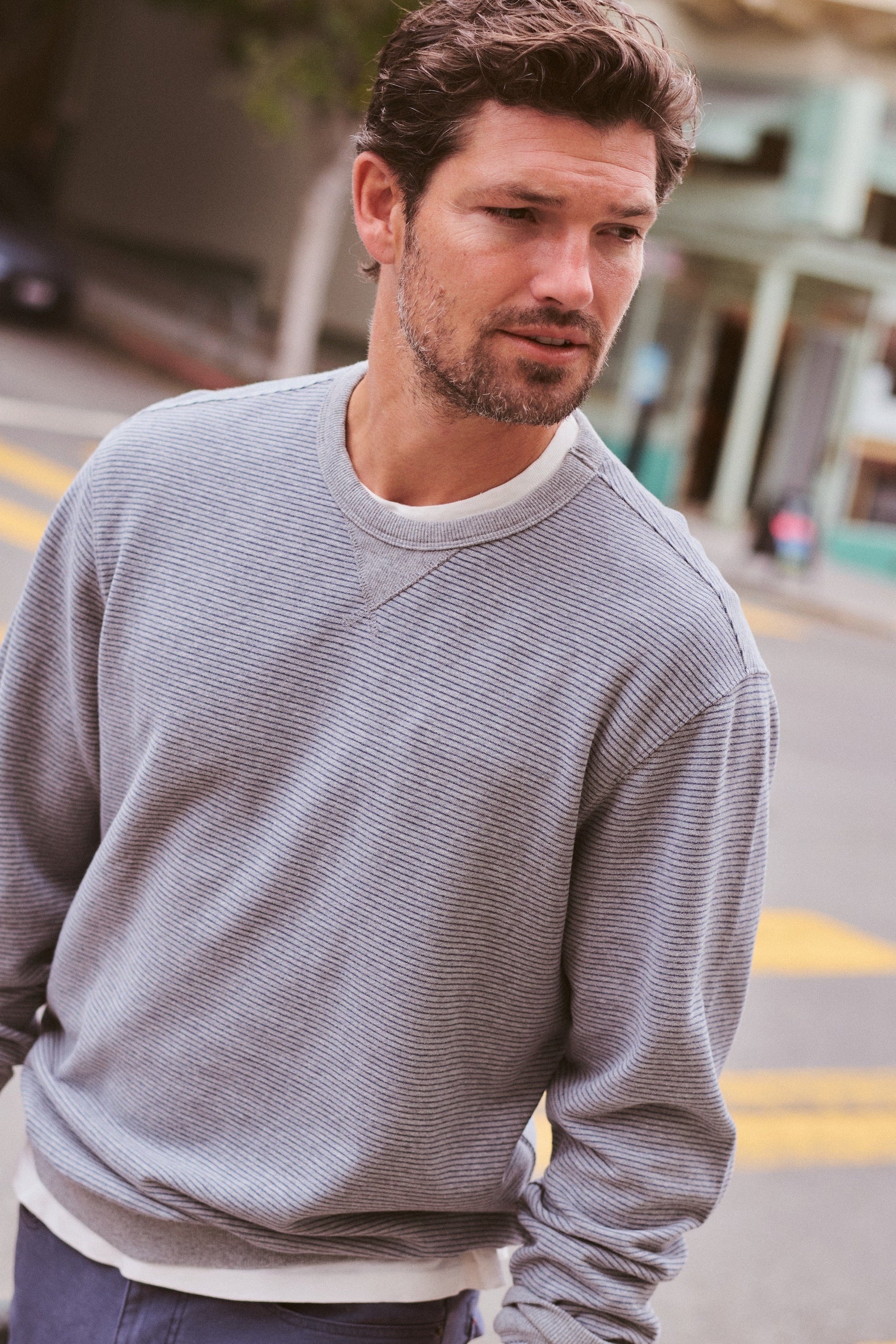 Marine Layer Cloud 9 Terry Relaxed Crewneck in Heather Grey Stripe layered under a bomber jacket