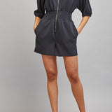 Sloane Zip Front Smocked Romper in Black - full length styled with heels