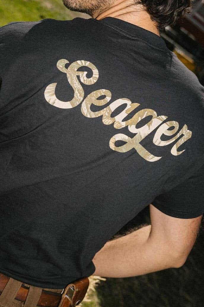 Man wearing the Seager Russ Fill Tee in Black, back graphic