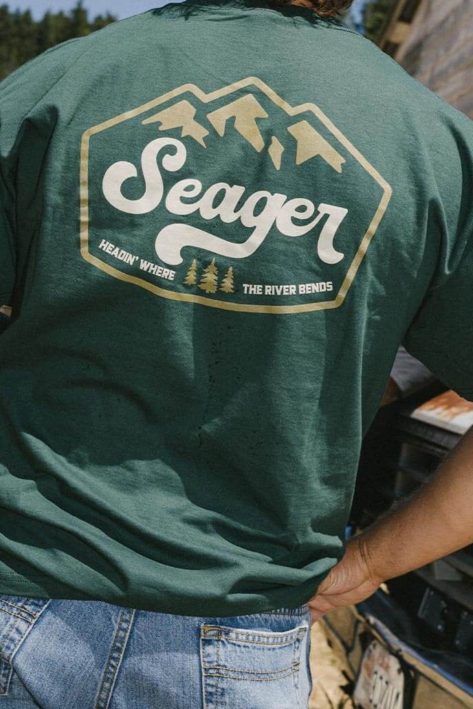 Man wearing the Seager High Country Tee in Forest Green, back graphic