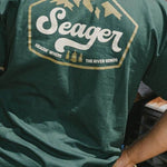Man wearing the Seager High Country Tee in Forest Green, back graphic
