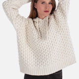 Woman wearing a cream knitted sweater on a white background