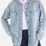 Woman wearing a light blue denim jacket on a white background