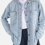 Woman wearing a light blue denim jacket on a white background