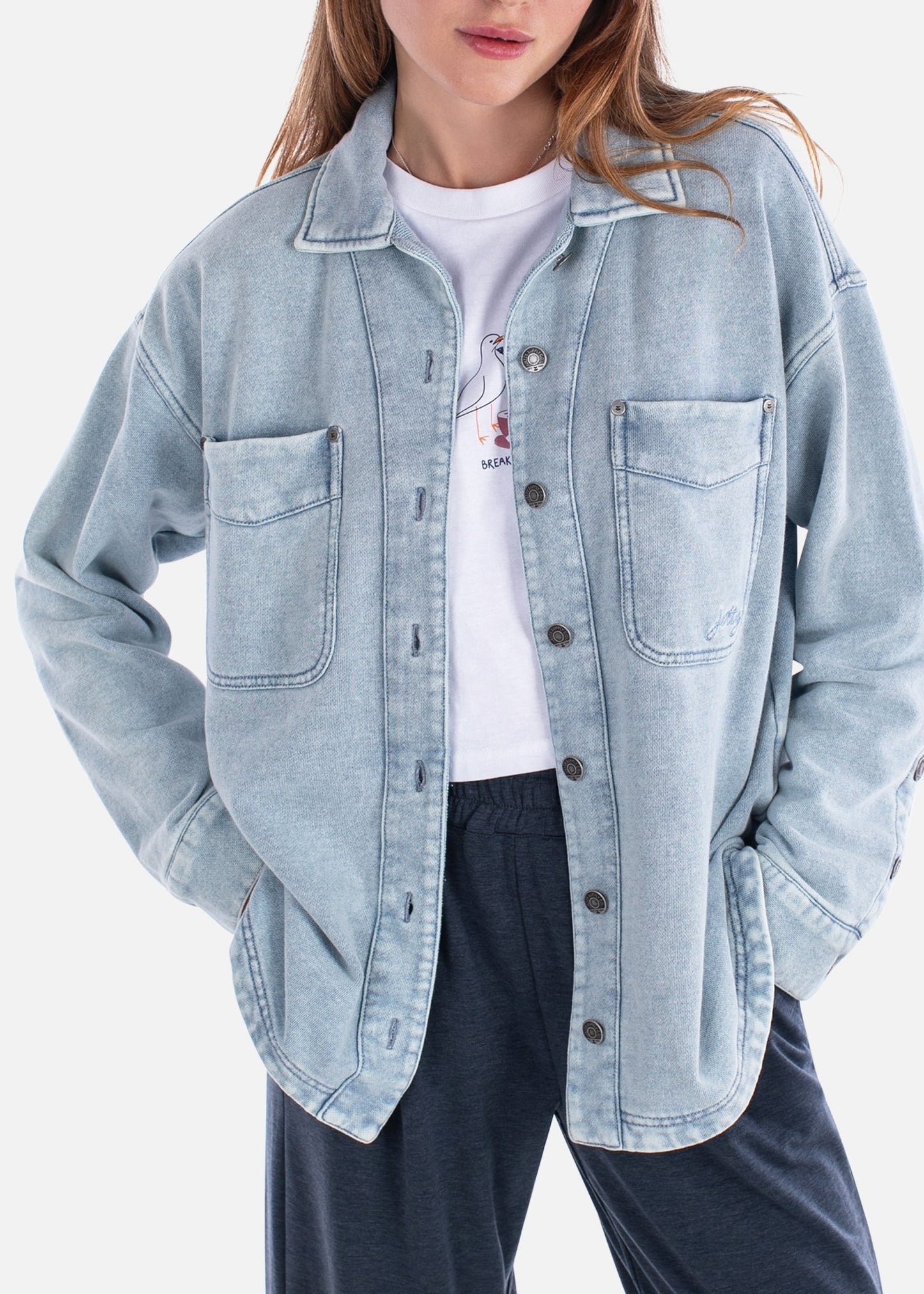 Woman wearing a light blue denim jacket on a white background