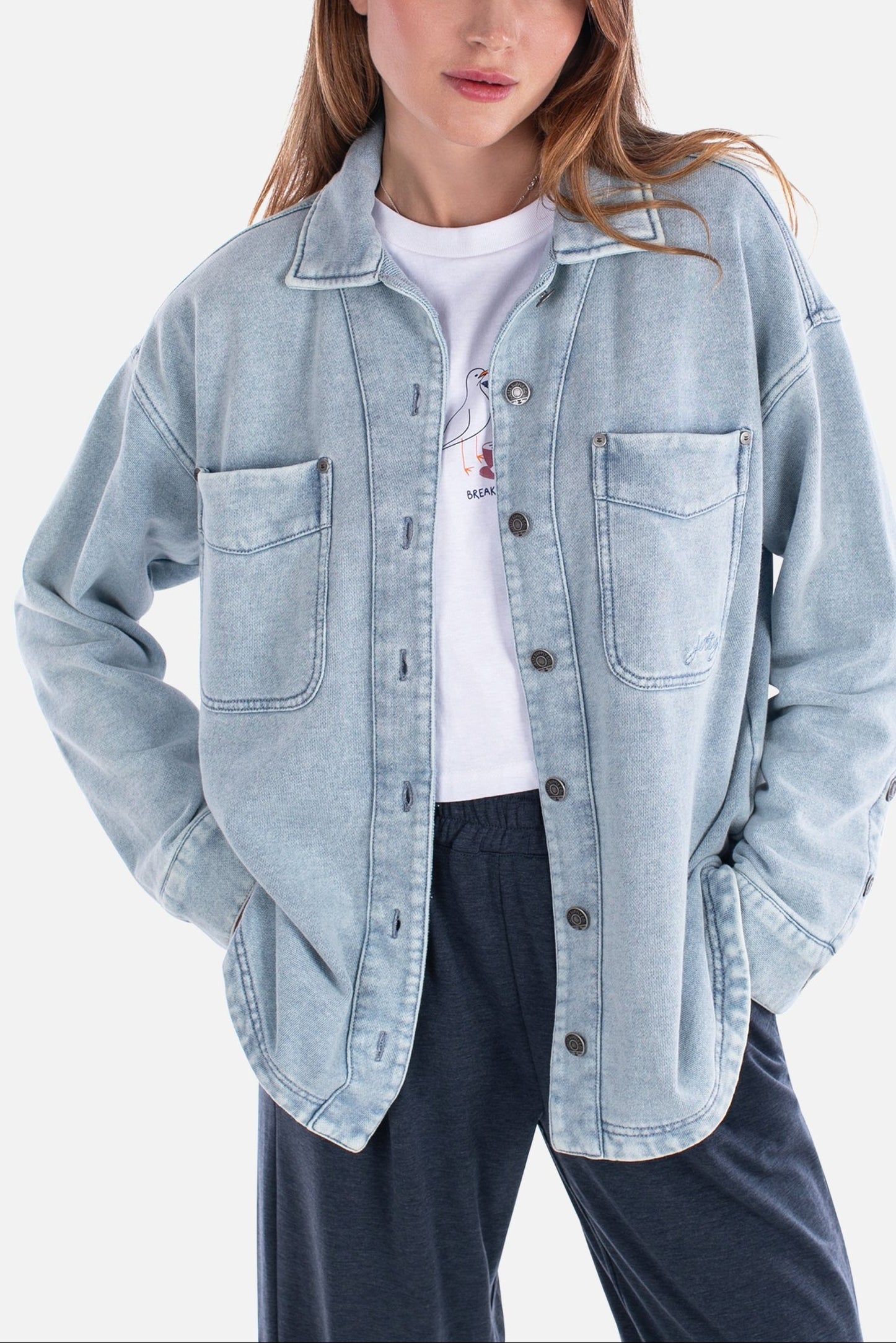 Woman wearing a light blue denim jacket on a white background