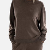 Woman wearing a brown sweatshirt and pants on a white background