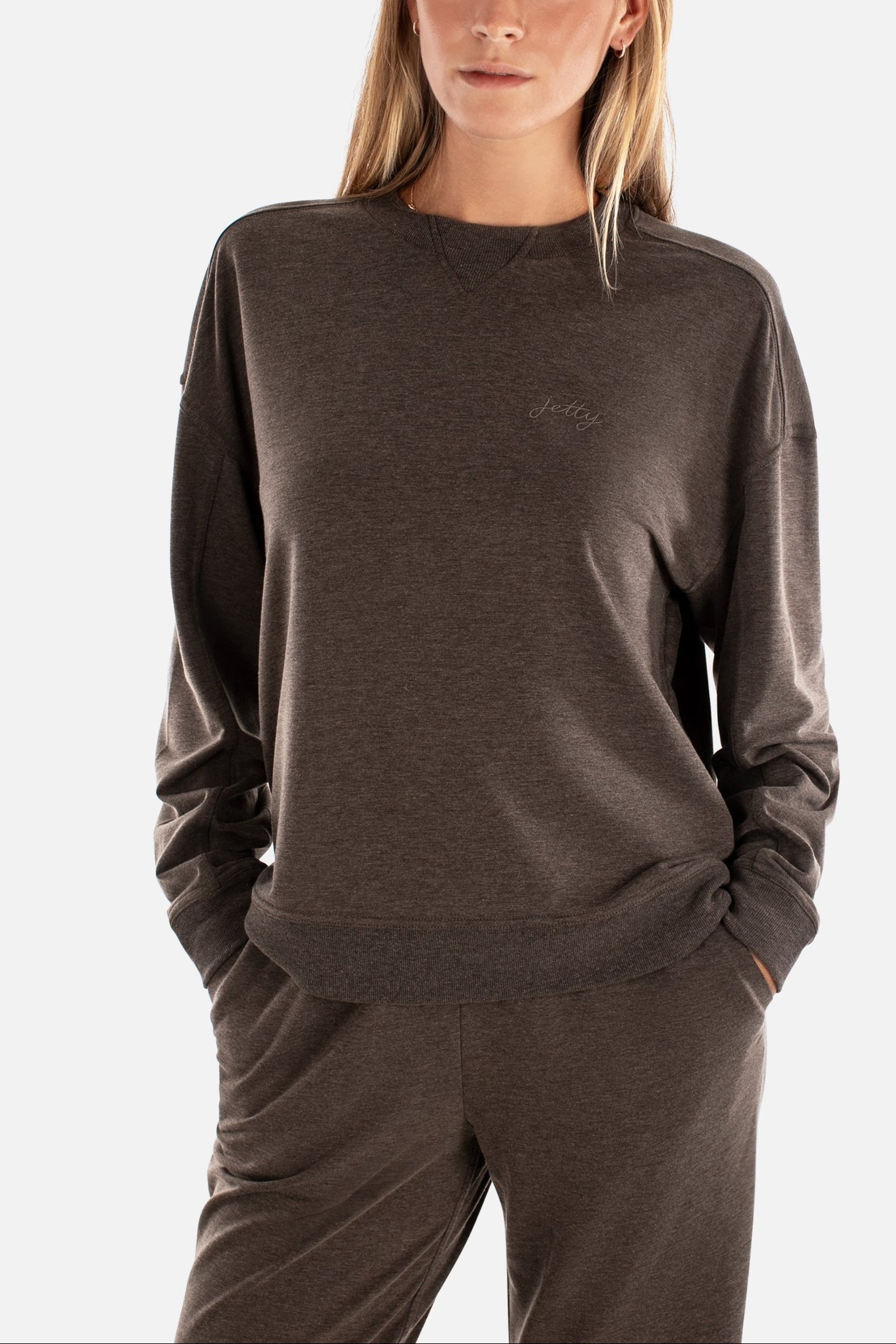 Woman wearing a brown sweatshirt and pants on a white background