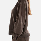 Woman wearing a brown sweatshirt and pants on a white background