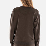 Person wearing a brown sweatshirt and pants on a white background