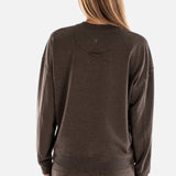 Person wearing a brown sweatshirt and pants on a white background