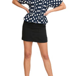 Woman wearing a navy blue polka dot blouse and black skirt on a transparent background
