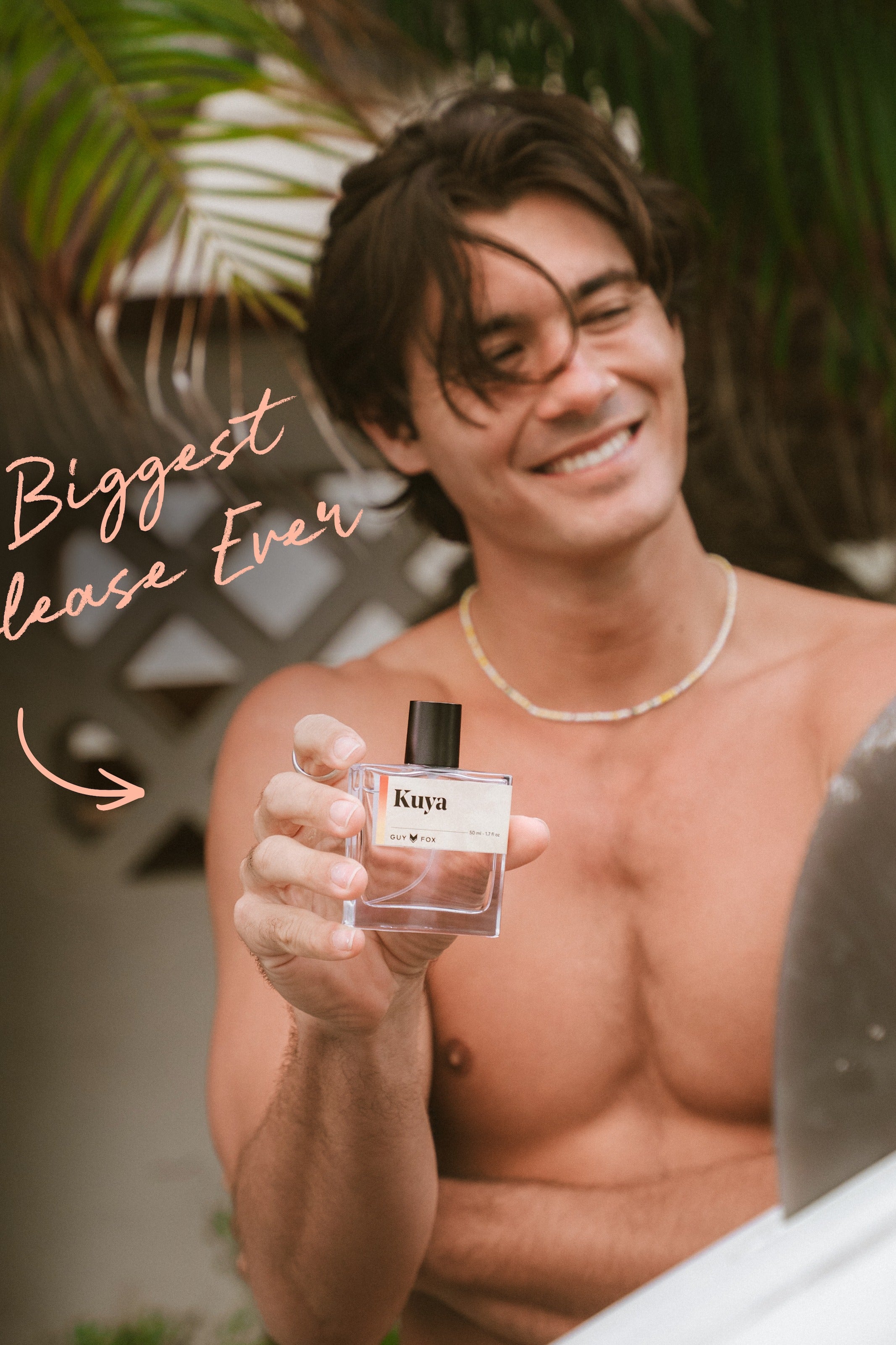 Man holding Kuya cologne on a tropical beach