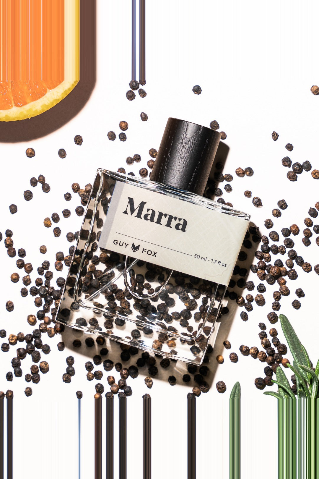 Guy Fox Marra cologne bottle flat lay with black peppercorns and citrus