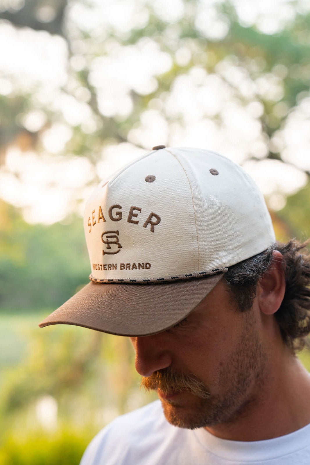 Man wearing the Seager Branded Snapback in cream and brown