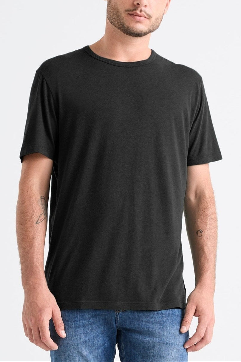 Man wearing a black t-shirt and blue jeans on a white background