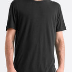 Man wearing a black t-shirt and blue jeans on a white background