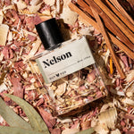 Guy Fox Nelson cologne bottle flat lay with cedar wood shavings