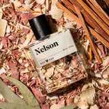 Guy Fox Nelson cologne bottle flat lay with cedar wood shavings