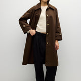 Brown midi trench coat worn open over a knit top