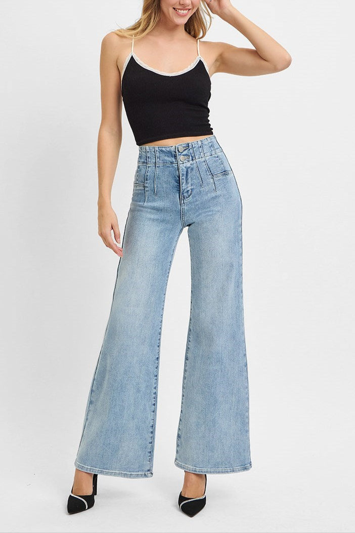 Woman wearing a black tank top and light blue jeans on a white background
