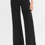 Black wide-leg jeans worn by a person on a white background