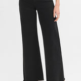 Black wide-leg jeans worn by a person on a white background