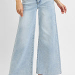 Light blue wide-leg jeans worn by a person on a white background