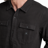 Close-up of a black shirt with a brand logo on a white background