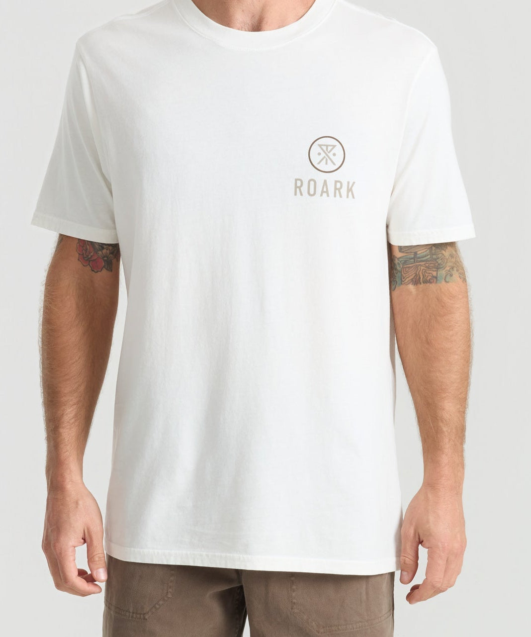 Man wearing white Roark t-shirt with small logo on chest