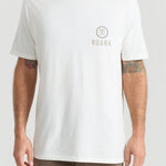 Man wearing white Roark t-shirt with small logo on chest