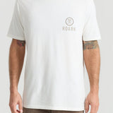 Man wearing white Roark t-shirt with small logo on chest