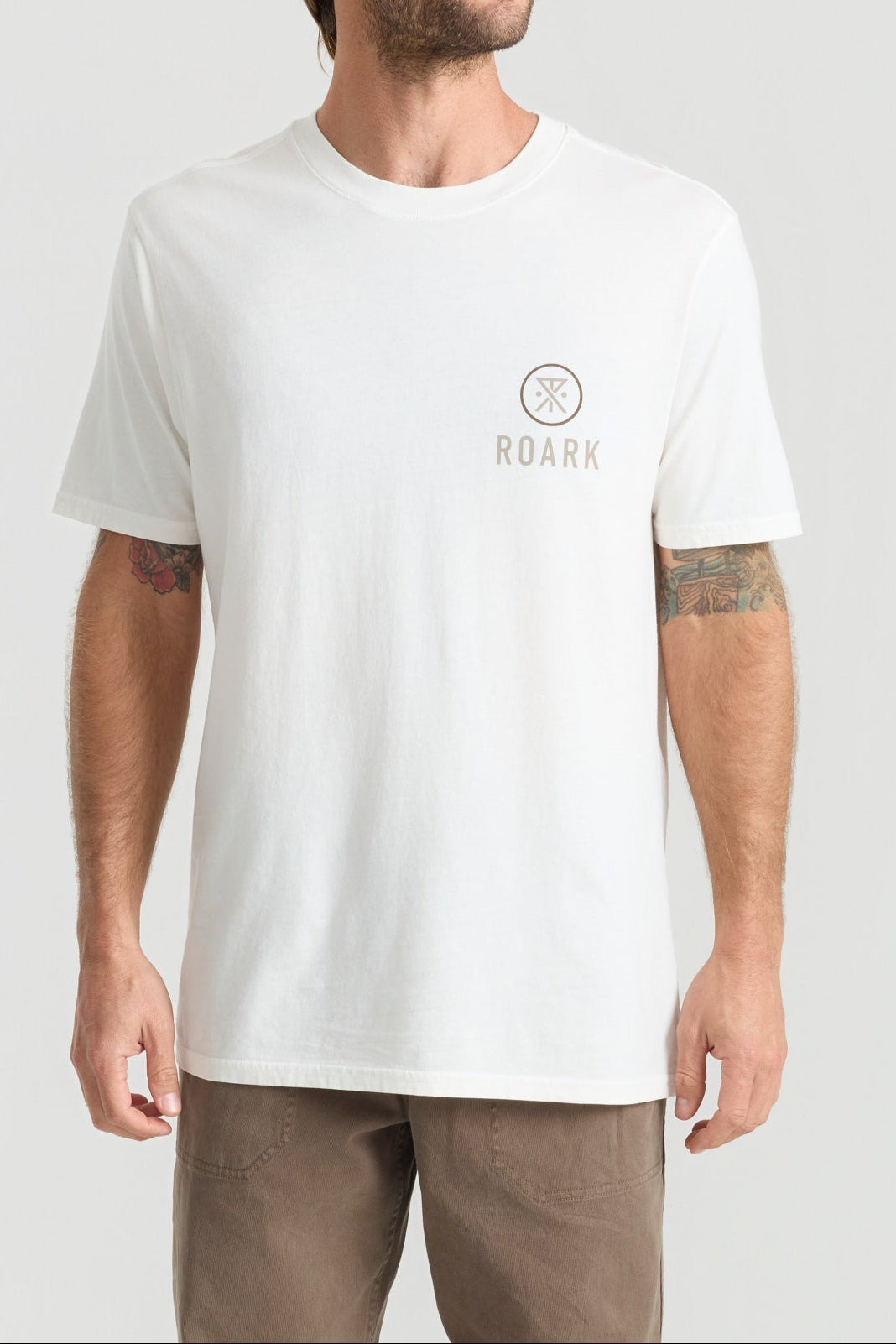 Man wearing white Roark t-shirt with small logo on chest