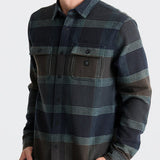Man wearing a plaid shirt with a neutral background