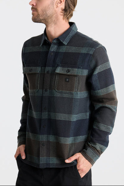 Man wearing a plaid shirt with a neutral background