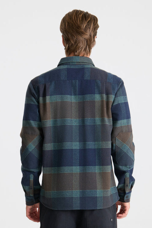 Person wearing a blue and green plaid shirt on a white background
