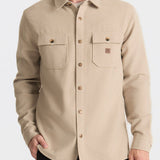 Man wearing a beige button-up shirt on a light gray background