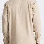 Man wearing a beige shirt on a white background