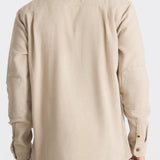 Man wearing a beige shirt on a white background